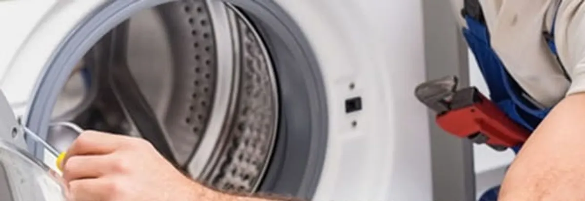 Appliance technician repairing a clothes dryer drum and internal parts in Oklahoma City, OK